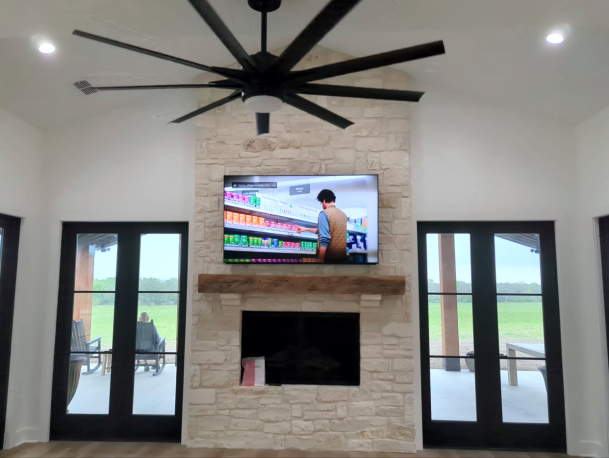 Living room with stone fireplace and mounted TV