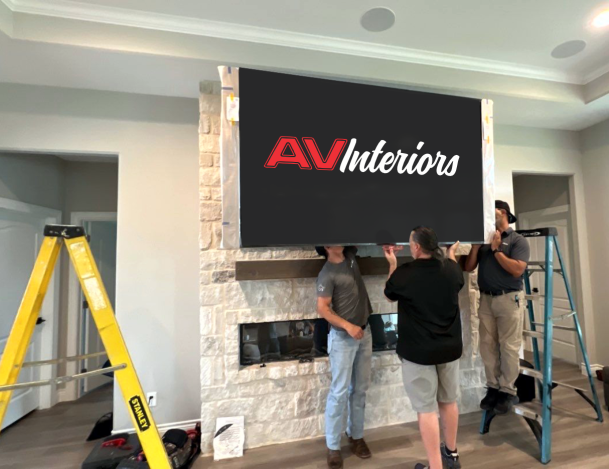 Technicians installing AV Interiors TV above fireplace